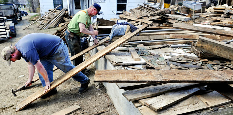Patrick, left, and Harlan Prescott on Sunday pound nails out of boards pulled from a barn they are taking apart at the former Quimby dairy farm in Augusta. Father and son started disassembling the three story hay barn built in 1920 in mid-March and plan to sell the wood recovered from the structure. "We salvage everything, including the nails," Harlan Prescott said.