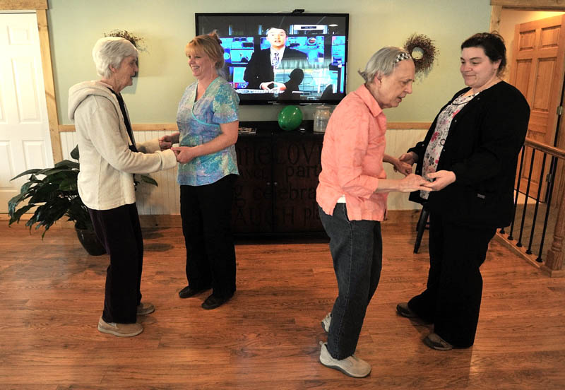 Martha Fabian, far left, dances with Debi Braun, alongside June Meres and Maribeth Beland, far right, in the dayroom at Bedside Manor on Belgrade Road in Oakland on Wednesday. Fabian and Meres are both residents at the 10-bed Alzheimer's care facility in Oakland, operated by Fabian's son, E.J Fabian, and daughter, Julie Benecke.