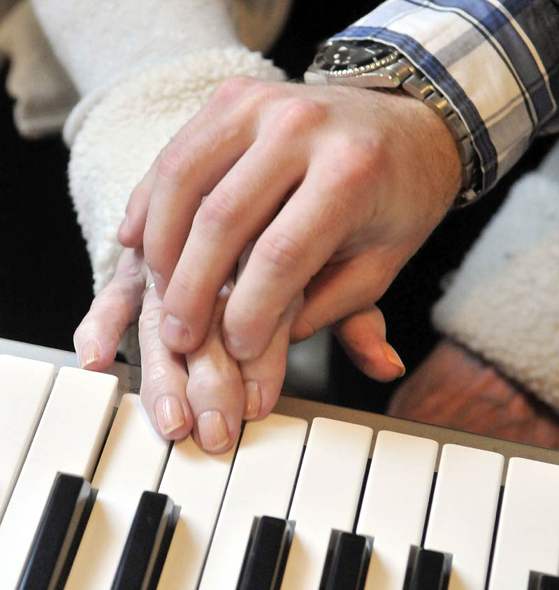 Scott McManaman gently helps Martha Fabian play "Chopsticks" on the keyboard, at Bedside Manor on Belgrade Road in Oakland on Wednesday.