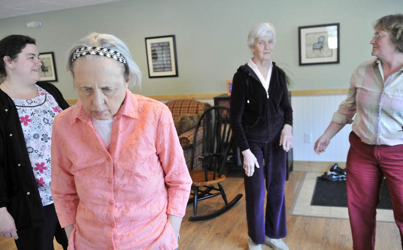 June Meres, left center, and Martha Fabian, right center, both Alzheimer's patients at Bedside Manor on Belgrade Road in Oakland, visit with Christine Pillsbury, far right, under the supervision of care attendant Maribeth Beland, far left, on Wednesday.