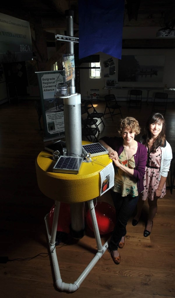 Denise Bruesewitz, an associate professor at Colby College, and Theresa Petzoldt, 21, an environmental studies major, stand next to "Goldie," a research buoy, at the Maine Lakes Resource Center in Belgrade on Friday.