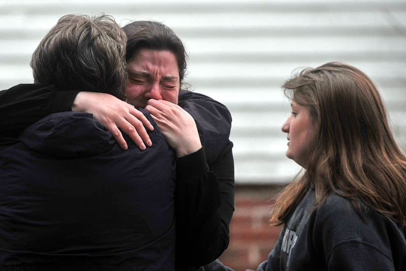 Maribeth Beland, 30, facing, is comforted by an unidentified woman as firefighters from Waterville, Winslow and Fairfield battle a fire at 10 Maple St. in Fairfield, where she lives, on Tuesday.