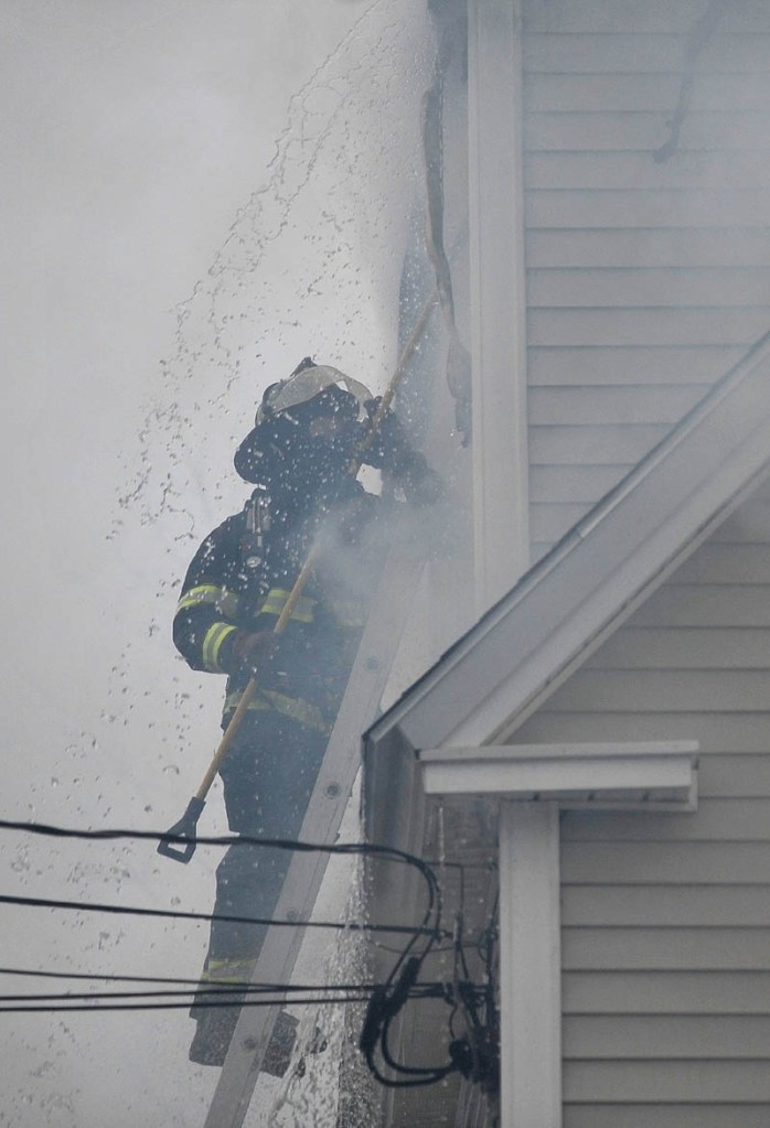 Firefighters from Waterville, Winslow and Fairfield battle a fire at 10 Maple St. in Fairfield on Tuesday.
