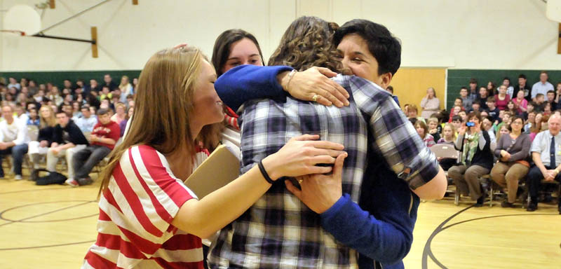 Marisa Weinstein, right, is embraced by former students after Weinstein, music teacher at Warsaw Middle School was presented with the Maine Music Educators Association Educator of the Year award.