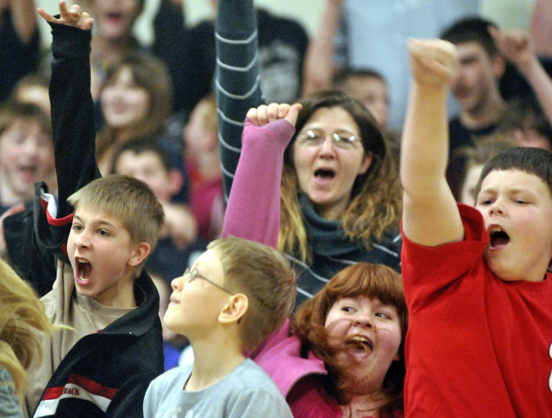 Warsaw Middle School sixth-grade students, DJ Neil, left, Anthony Dow, left center, Ashley Humphrey, right center, and Cody Marquis, right, cheer during an assembly recognizing music teacher Marisa Weinstein.