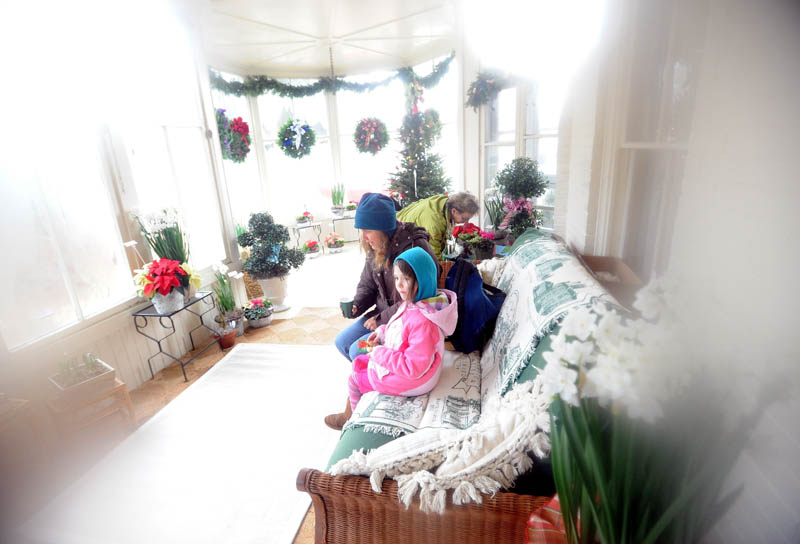 Mia Lambert, 6, of Kingfield, sits with her friend, Eileen McGuire, on the sun porch of the Octagon House in downtown Farmington Saturday. The Farmington Historical Society recently opened the home for tours.