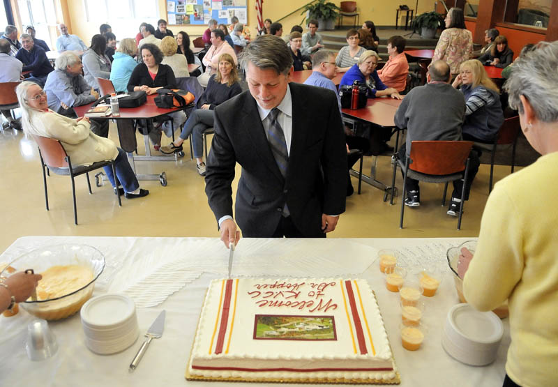 Richard Hopper cuts a cake in his honor, as new president of Kennebec Valley Community College in Fairfield, on Monday.