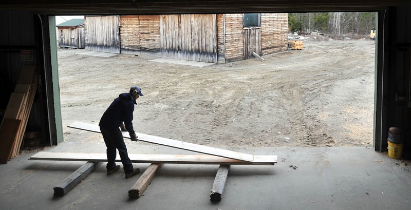 Josh Saltmarsh, co-owner of The Wood Mill of Maine on Mercer Road in Mercer, stacks wood as it comes off a planer on Friday.