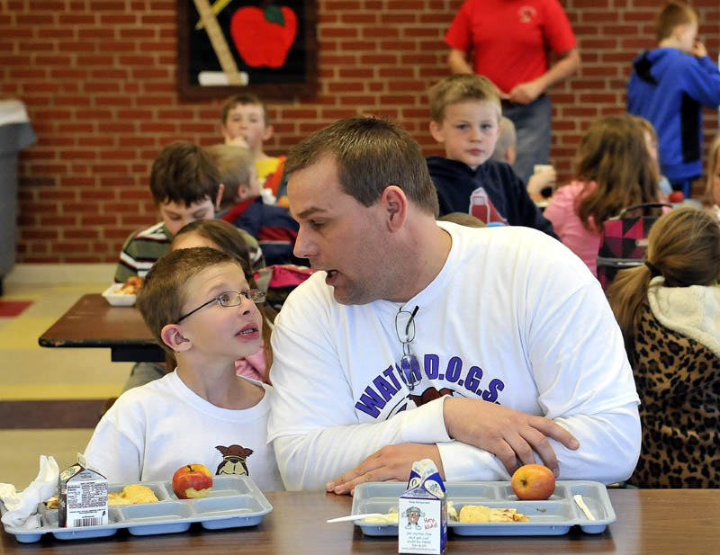 Todd Atwood, a volunteer Watch Dog at Belgrade Central School sits with his son Luke, 8, during lunch on Thursday.