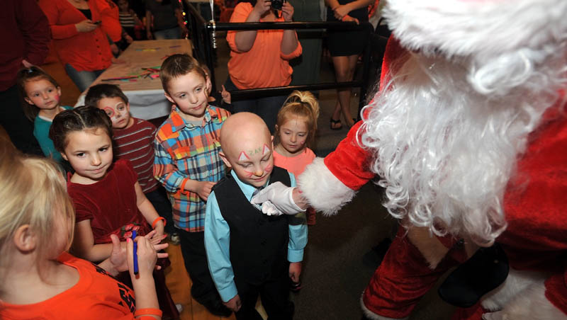 Zachary Korbet, 4, is greeted by Santa Claus at Champions in Waterville on Saturday. Korbet was diagnosed with leukemia in January and is receiving treatment at Maine Children's Cancer Program in Scarborough. Santa's visit was part of a benefit to help offset treatment costs. The Christmas theme was catered to Zach's affinity for the holiday.
