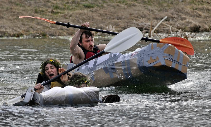 Hannah Rhea, 20, left, paddles with her partner, Mike Froehly, 20, not seen, ahead of Colby Smith, 28, back, in the first heat of the cardboard kayak race at Unity College on Friday. Students had one hour to fabricate kayaks from cardboard, tape and plastic.