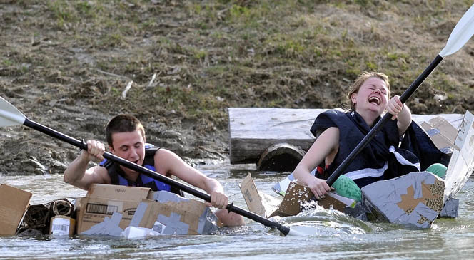 Chris Iacozzi, 18, left, and Summer Nay, 20, race in the third heat of the first cardboard kayak race at Unity College on Friday.