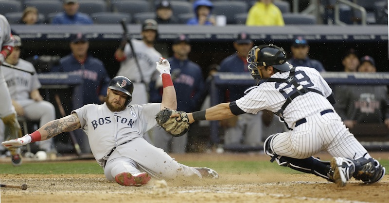 Boston’s Jonny Gomes beats the tag of Yankees catcher Francisco Cervelli as he scores on a single by Jacoby Ellsbury in the ninth inning at New York. Gomes had two hits in the Red Sox 8-2 opening-day win on Monday.