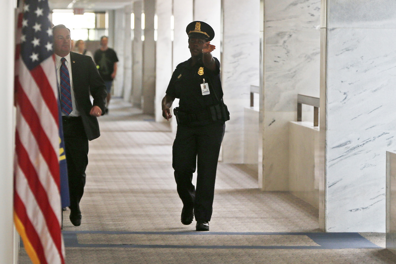A Capitol police officer tells people to clear the hallway on the third floor of the Hart Senate Office building after suspicious packages were discovered on Capitol Hill in Washington on Wednesday.