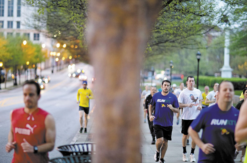 Runners jog along Peachtree Street as part of an organized moment of silence and memorial run to show solidarity with victims of the Boston Marathon bombing, Tuesday, April 16, 2013, in Atlanta. The explosions Monday afternoon killed at least three people and injured at least 100 others. (AP Photo/David Goldman)