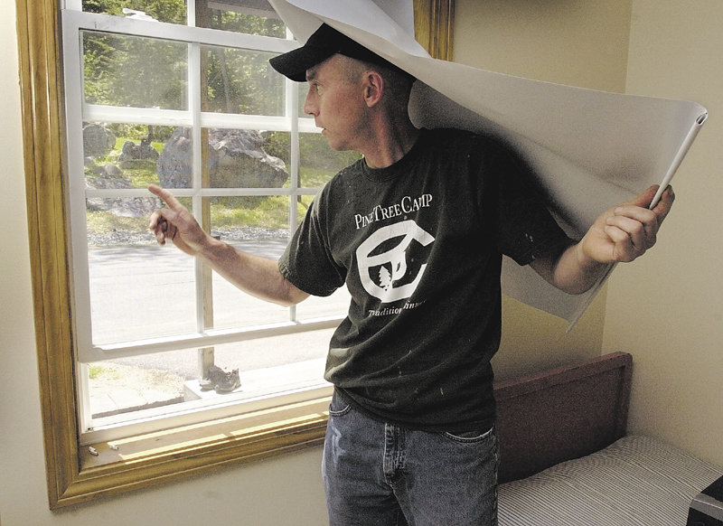 Harvey Chesley, then-director of Pine Tree Camp, shows a window that was carefully forced open, but not broken, to get at food in one of the camp's buildings in 2005.