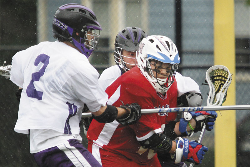 GAINING MOMENTUM: Messalonskee’s Nate DelGiudice works against two defenders from Deering during a game in 2011. Lacrosse has slowly made its way up from York and Cumberland County into central Maine since the Maine Principals’ Association first sponsored the sport in 1998.