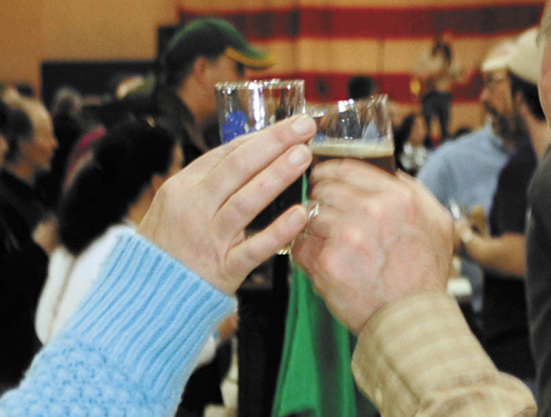 John Chapin, left, and Diana Chapin, of Montville, clink sample glasses on Saturday during the Central Maine Brew Fest at the Augusta armory.