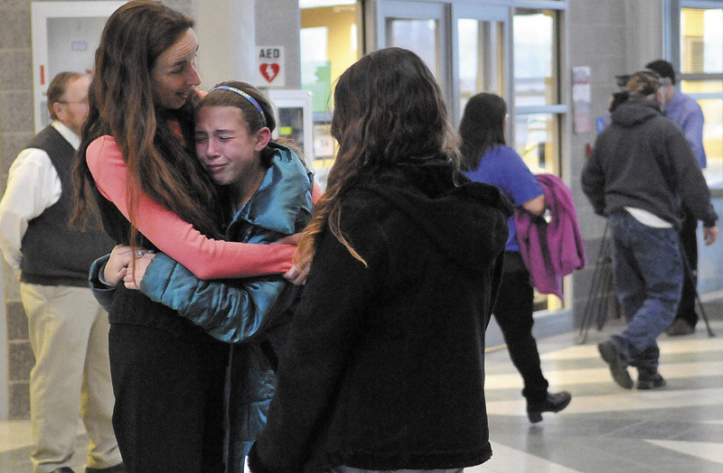 Deb McIntyre, left, comforts Katelin Lewis, 11, center, a sixth-grader at Mount View Middle School, in the hall of Mount View High School following the community forum on suicide prevention and grieving on Thursday evening.