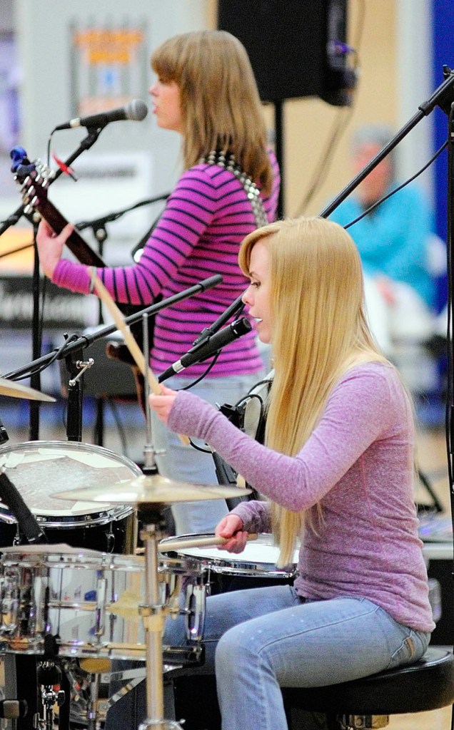 Kristen Veayo, top, and her sister, Katherine Veayo, perform a song during a school assembly on Wednesday at Windsor Elementary School. The Hall-Dale High School students, who perform as The Veayo Twins, spoke about dealing with bullying between performing covers of hit songs along with several of their own compositions.