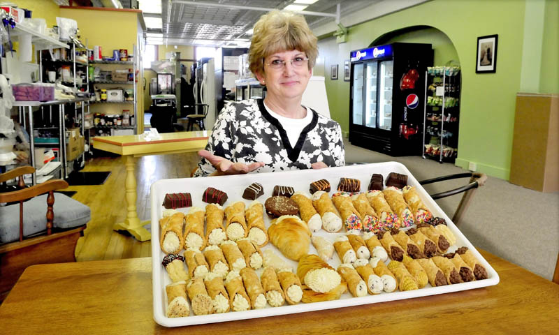 Holy Cannoli owner Candace Savinelli offers a tray full of Italian pastries at her new shop on Main Street in Waterville. The business outgrew the original store and is now located a short distance away, at the former Adams & Worth store.