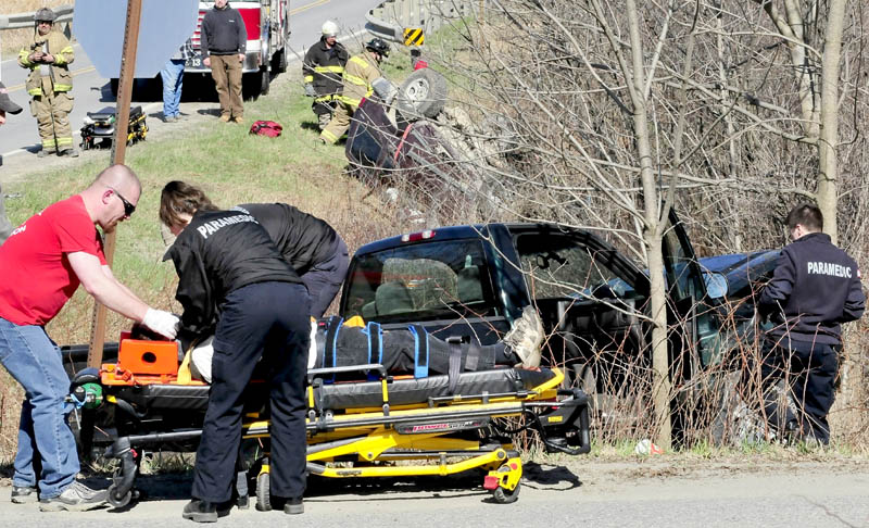 Rescue workers remove an injured occupant of a truck as another injured person in the background is removed from an SUV following an accident on Route 43 in Cornville on Thursday.
