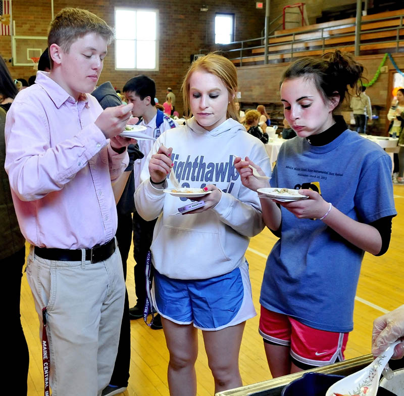 Maine Central Institute students from left, Dylan Maloon, Courtney Fowler and Hailey Stewart sample a pork and shrimp dish during the International Food Festival in Pittsfield on Saturday. Between mouthfuls Fowler said the food was "real good."