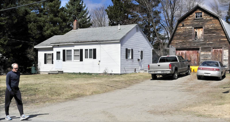 A pedestrian passes 202 Maple Ave. in Farmington, where police were investigating the deaths of two people, found in the home early Monday morning.
