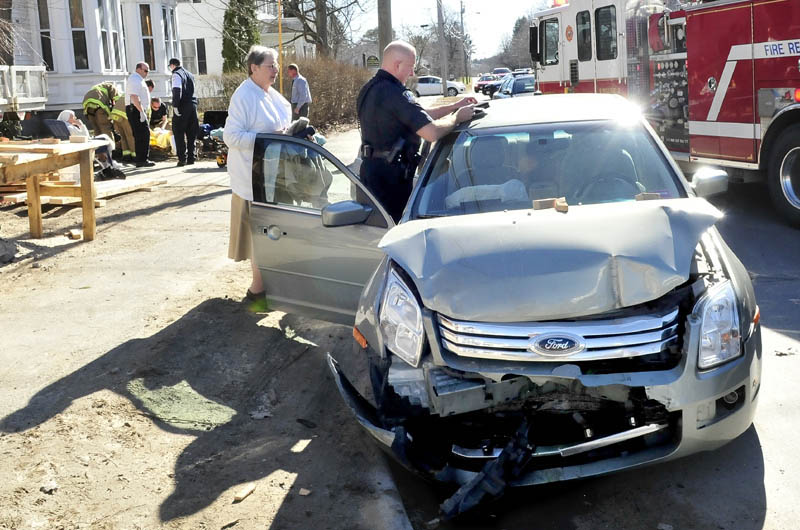 Waterville police officer Tim Hinton collects information from the vehicle that contained Sister Josephine Roney, left, as two other sisters in background are treated and transported to the hospital following an accident on Silver Street in Waterville on Wednesday. Sister Josephine Roney said the nuns vehicle struck a parked truck near the Servants of the Blessed Sacrament chapel.