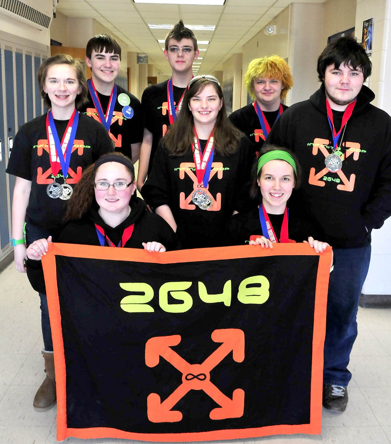 Members of the Messalonskee High School 2648 FIRST Robotics club at the Oakland school on Monday. Co-captains McKenzie Brunelle, left front, and Sabine Fountaine, hold the team banner along with members, from left, Taylor Ferguson, Robert Klein, Amy Pinkham, Brady Snowden, Bradley Bickford and Justin Shuman. The team won first place recently in regional competition and will advance to the world championship.