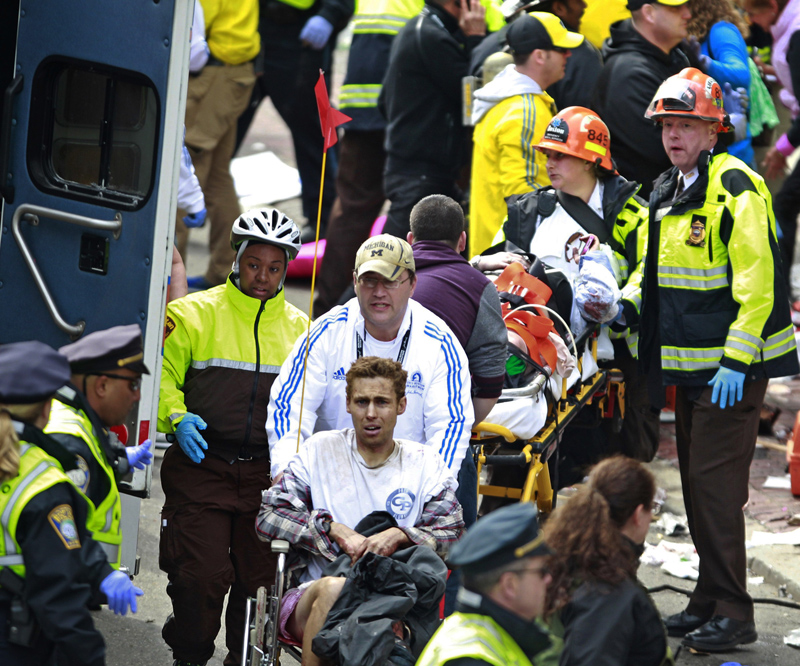 Medical workers aid injured people at the finish line of the 2013 Boston Marathon following an explosion in Boston, Monday, April 15, 2013. Two explosions near the finish of the Boston Marathon on Monday, killing at least two people, injuring over 20 others. (AP Photo/Charles Krupa)