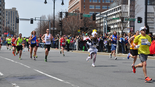 Runners approach the “1 Mile To Go” marker Monday afternoon at the Boston Marathon. Just before 3 p.m. Monday, two bombs exploded 12 seconds apart at the marathon finish line, killing three and injuring 176 others.