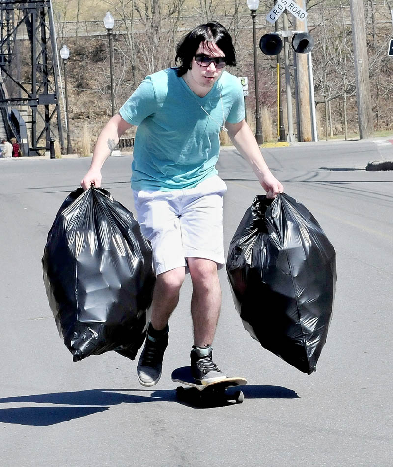 Troy Bowen uses his skateboard to make his way to Jokas redemption center in Waterville to cash in two bags of returnable cans.
