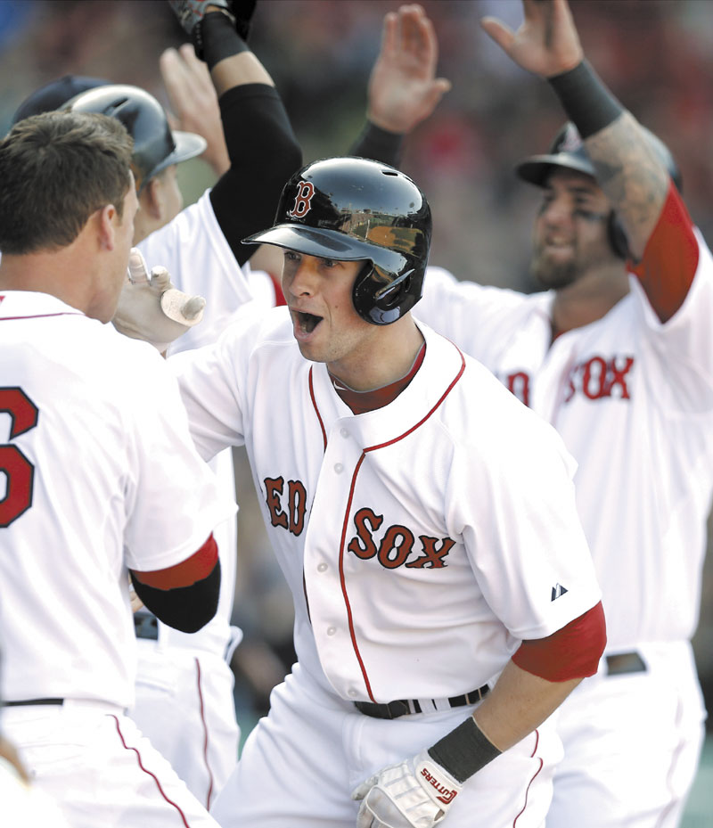 HOME SWEET HOME: Boston’s Daniel Nava is greeted by teammates after hitting a three-run home run in the seventh inning of the Red Sox’ 3-1 win over the Baltimore Orioles on Monday in Boston.