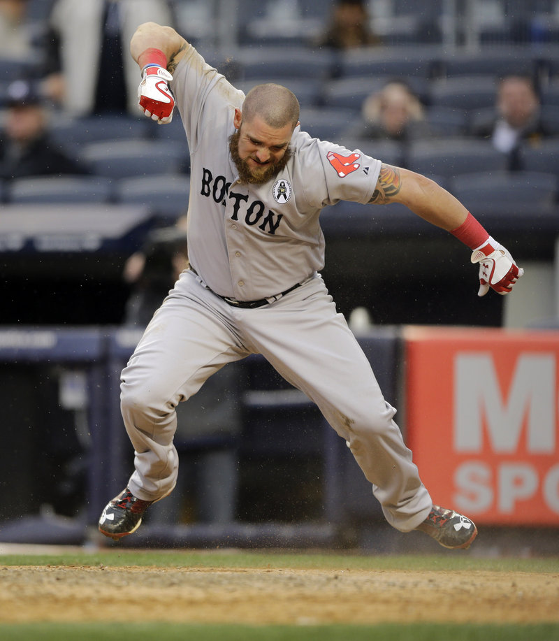 Boston’s Jonny Gomes is clearly pumped after scoring on a two-run, ninth-inning single by Jacoby Ellsbury during the Red Sox season-opening 8-2 win over New York at Yankee Stadium on Monday.
