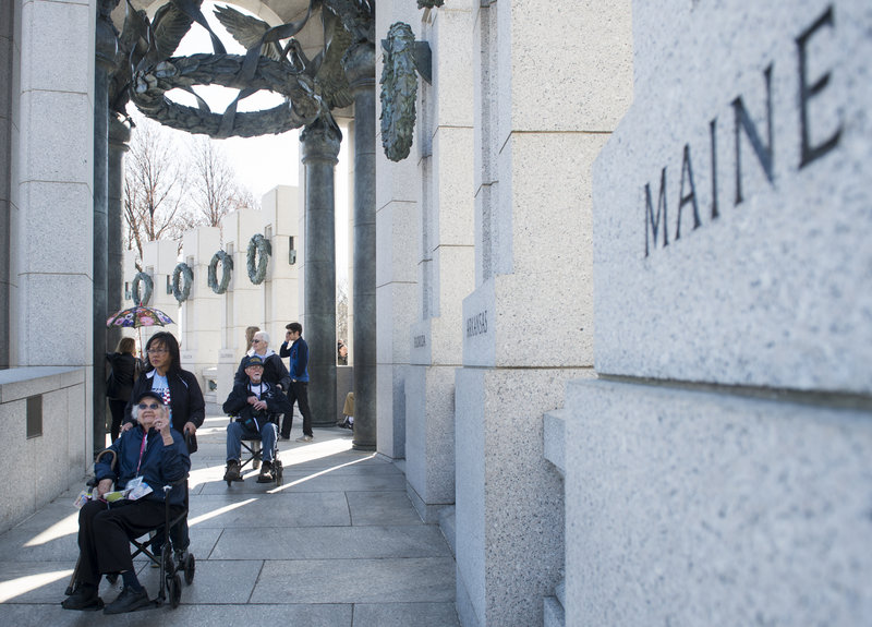 Veteran Dorothea Washburn, of Harrison, points to the Maine pillar Sunday as the Honor Flight New England tour arrives at the World War II Memorial in Washington. Washburn served as a Navy storekeeper 1st Class at the Brooklyn Navy Yard.