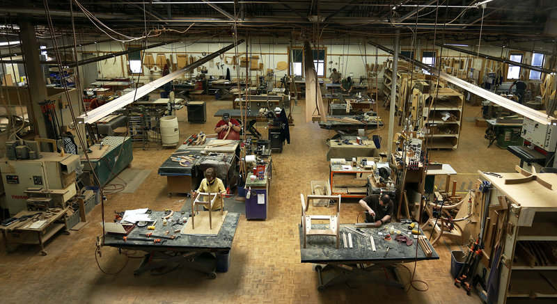 Cabinetmakers assemble chairs Thursday at the Thos. Moser facility in Auburn. Founded four decades ago by Bates College professor Thomas Moser, the company has built furniture for libraries and corporate boardrooms across the United States.