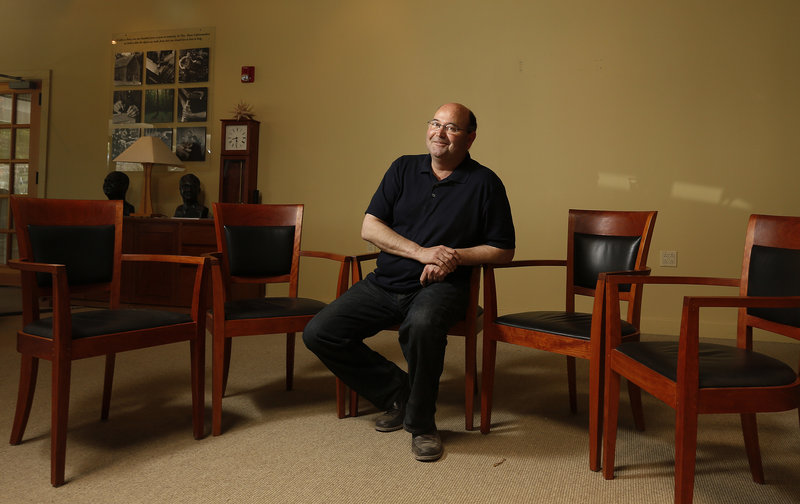 Aaron Moser sits Thursday in a Harpswell chair, one of the Thos. Moser company’s signature designs, at its headquarters in Auburn. He didn’t learn until Wednesday that Harpswell chairs would be on the stage at Thursday’s dedication of the George W. Bush library.