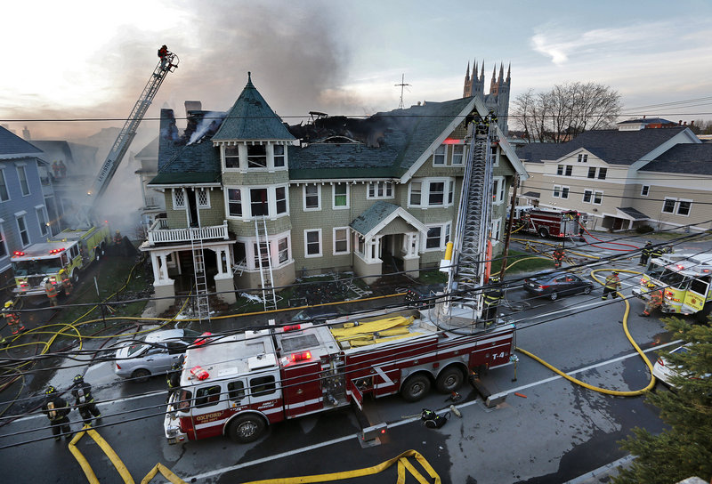 Firefighters battle a fire that began on Blake Street in Lewiston. Hundreds of spectators watched, and several blocks were cordoned off as the flames were fought from ladders and the ground.