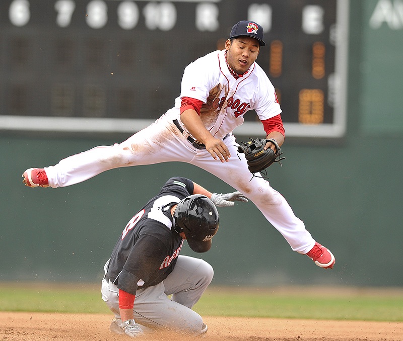 Second baseman Heiker Meneses of the Portland Sea Dogs vaults over Dan Rohlfing of the New Britain Rock Cats, throwing to first to complete a double play Saturday during a 7-1 victory. Portland moved over .500 for the first time this season.