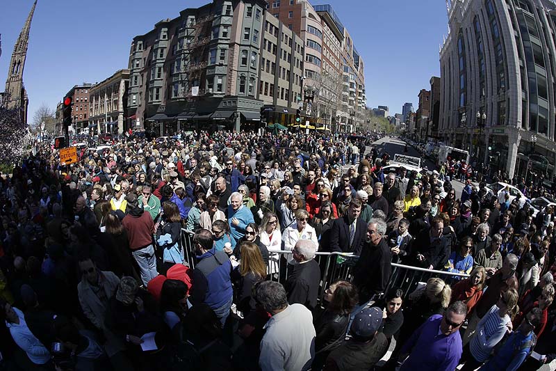 In this photograph made with a fisheye lens, people attend an interfaith service held near a makeshift memorial on Boylston Street, near the finish line of the Boston Marathon on Sunday.