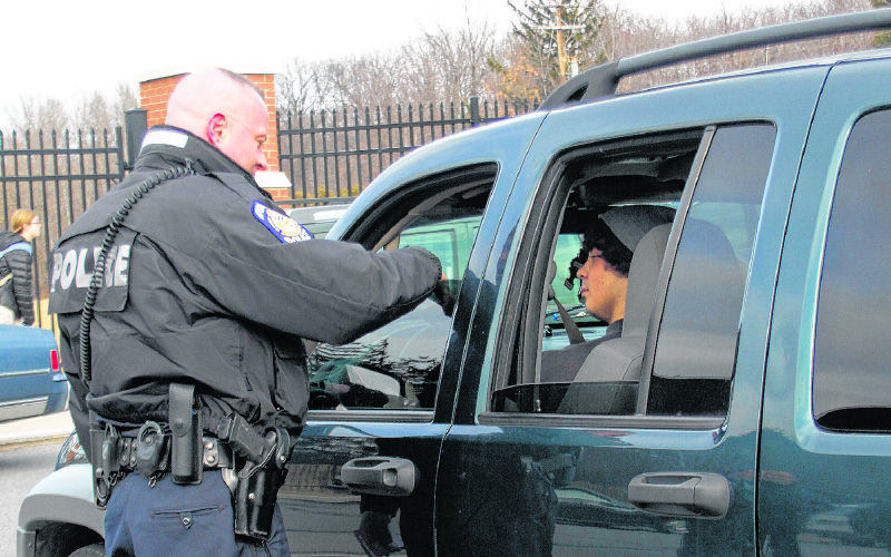 Patrolman Scott Perry from the Dunmore, Pa. Police Department distributes information cards on new seatbelt laws to students at Dunmore High School on Feb. 22, 2012. Augusta and Gardiner police will step up enforcement of seat belt laws over the next few weeks, as part of the national Click It Or Ticket campaign.