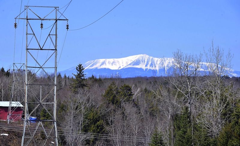 In this April 2011 file photo, Mt. Katahdin looms over electrical transmission lines that lead to the closed Katahdin Paper Mill and other hydroelectric dams along the Penobscot River. A legislative committee is expected to vote Friday, May 23, 2013 on an ambitious proposal aimed at lowering Maine's high electricity and heating costs.