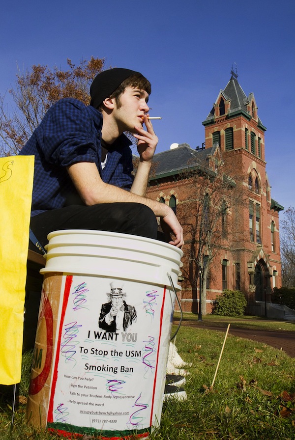 In this file photo, USM freshman Joshua Thornberg smokes during a protest of a proposed smoking ban on USM campuses at the Gorham campus on Monday December 3, 2012. Gov. LePage has vetoed a bill to ban smoking at all public Maine college campuses.
