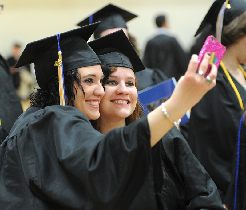 Mariah Bosse, of Scarborough, and Kristen Stearns from Lyman take photos of themselves prior to Saturday's 133rd commencement at the University of Southern Maine in Gorham.