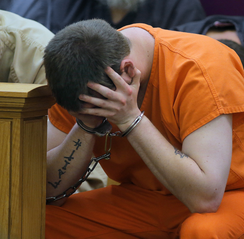 Bryan Wood of Lewiston holds his head in his hands before being arraigned on three counts of arson Monday in Lewiston District Court.