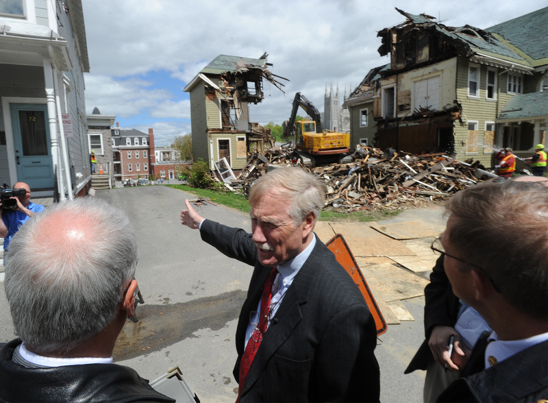 Maine Sen. Angus King tours the fire scenes in Lewiston with city officials Friday, including 80-82 Pine St., where a demolition crew is tearing down the building. King