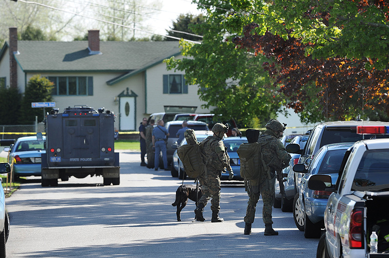 Members of the state police tactical unit join dozens of state and local police on Hillview Avenue in Saco during a standoff with a man in a house on this street beyond the house seen in background.