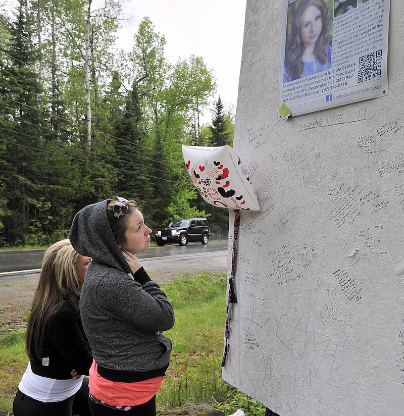 Cousins Ashley Look, left, and Alicia Eaton view the notes left by friends and relatives as they visit the memorial to Nichole Cable who was allegedly murdered by an acquaintance. Photographed on Tuesday, May 21, 2013,