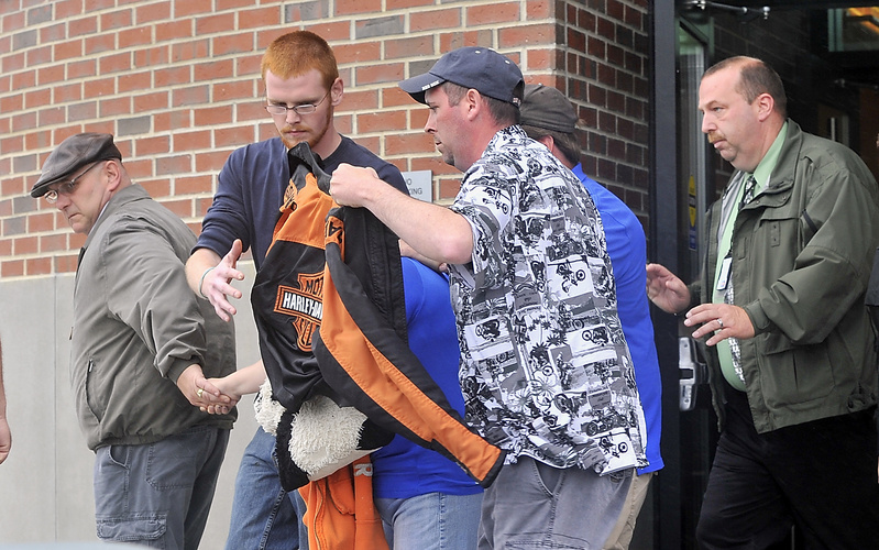 Nichole Cable's mother is being shielded by a coat as her family leaves Penobscot County Superior Court in Bangor on Wednesday after Kyle Dube's arraignment on a charge of murdering Nichole.